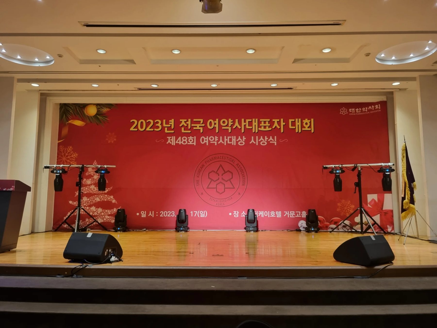 기념식 사회자 현장, 실내 무대 현수막이 걸린 신용주 진행 모습 (mc-wide-08)